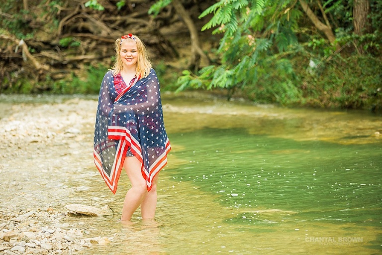 July 4th styled senior portraits of a Carrollton Hebron high school senior student standing in the water river creek. www.chantalbrownphotography.com