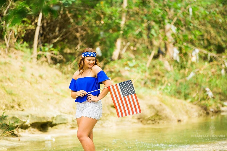 Very cute patriotic clothes of an All American girl holding flag and standing in the water creek river. Taken by Dallas Chantal Brown Photography. www.chantalbrownphotography.com